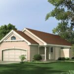 A cozy single-story ranch-style home with a light beige exterior and brown shingled roof. The house features an attached two-car garage with a curved arch design on the garage door, a small covered front porch with two white columns, and a well-maintained green lawn surrounded by trees and shrubs. The front gable roof and simple architectural lines add to the home's traditional appeal, blending modern functionality with classic design elements. The house is set in a peaceful suburban environment with lush greenery.
