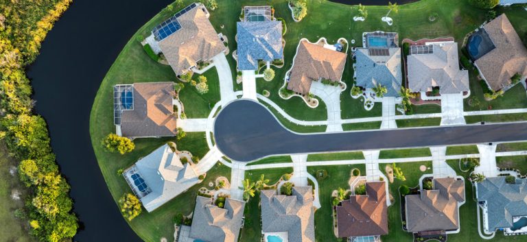 A picture of residential homes with pools in Gainesville, Florida near a retention pond.